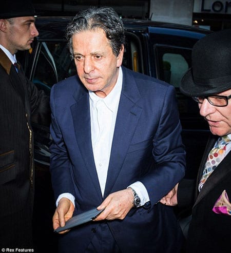 Charles Saatchi pictured outside Richard Caring's restaurant, 34, without his wife this week