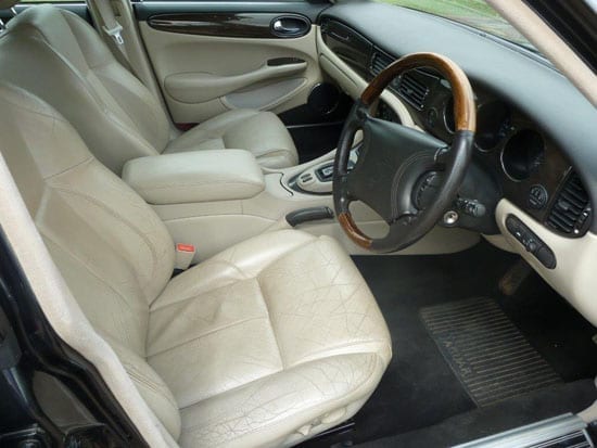 The car's interior looks clean but the leather seats show some signs of cracking