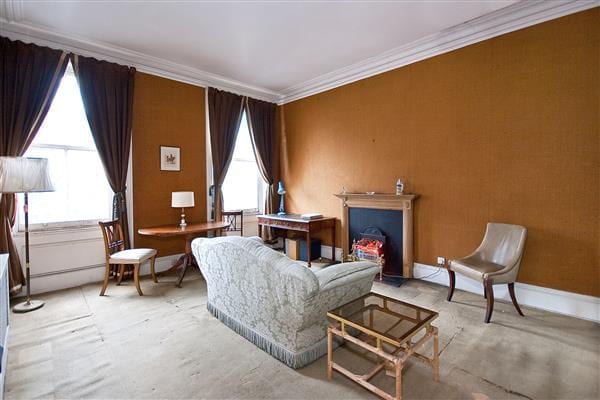 The sitting room is spacious but plainly needs redecoration
